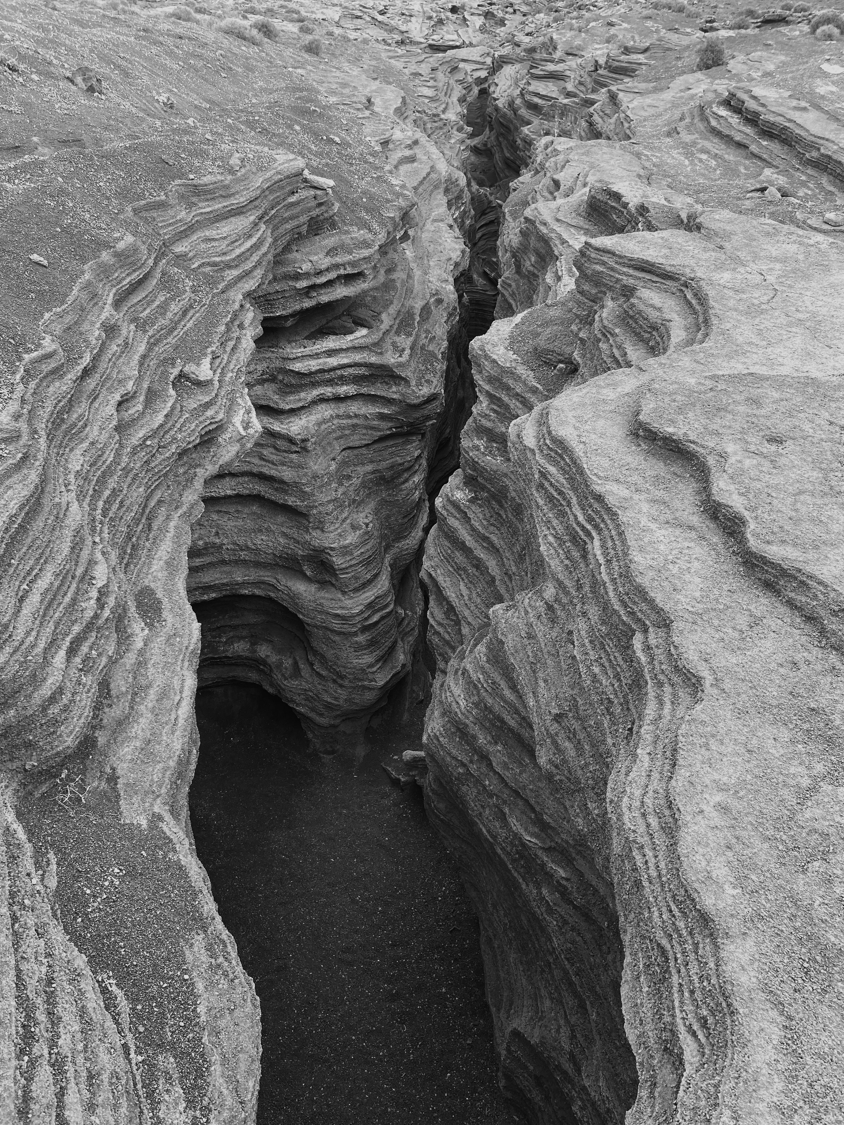 a black and white photo of a crack in the ground