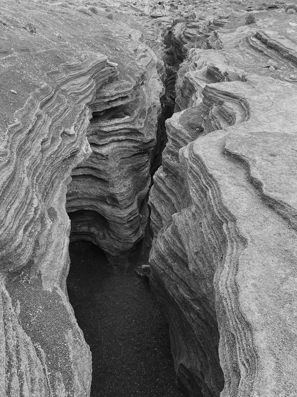 a black and white photo of a crack in the ground