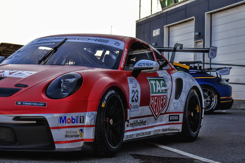 a red and white race car parked in a parking lot