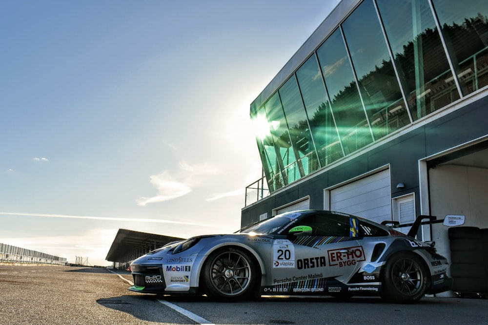 a silver sports car parked in front of a building