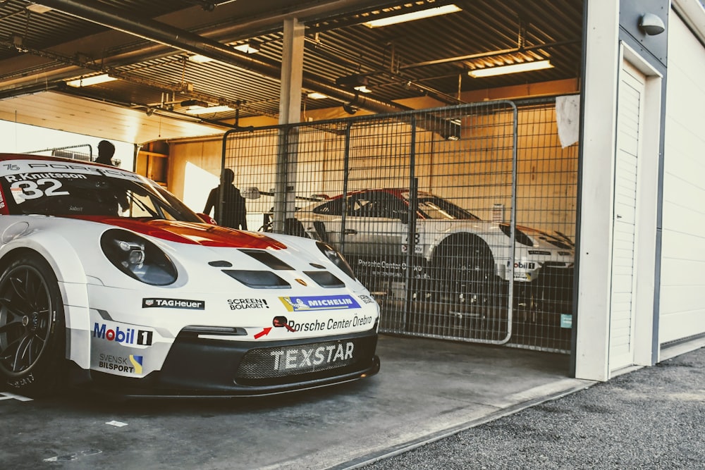 a white and red race car parked in a garage