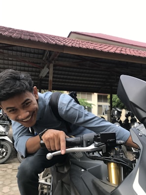 Close-up of a smiling team member assisting a customer with motorcycle paperwork.