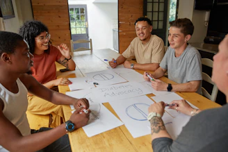 a group of people sitting around a wooden table