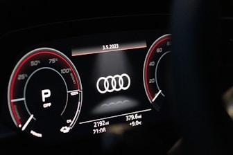 Technician performing SCN coding on an Audi dashboard with high-tech equipment.