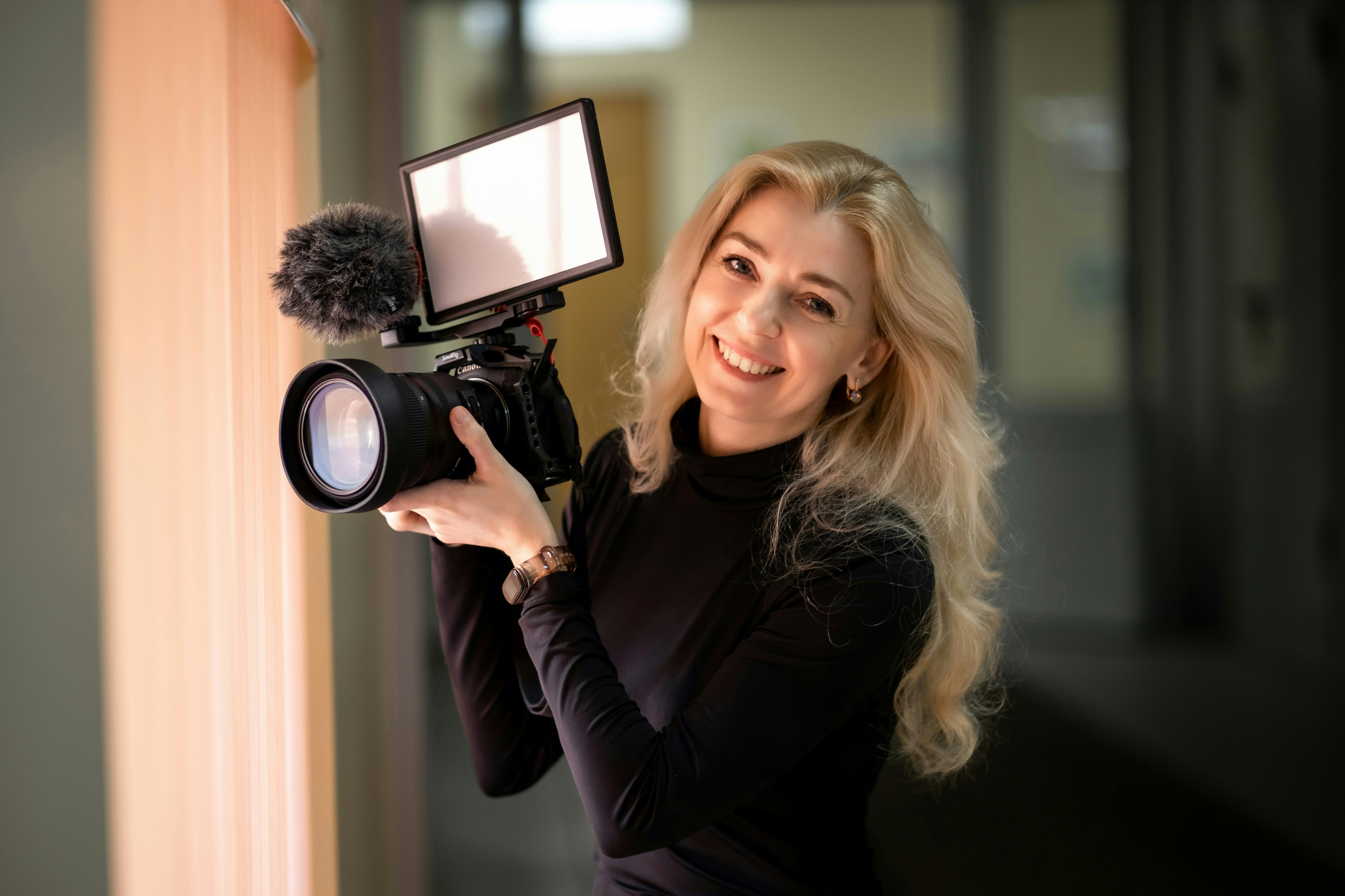 a woman holding a camera and a microphone