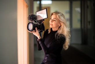 a woman holding a camera up to a mirror