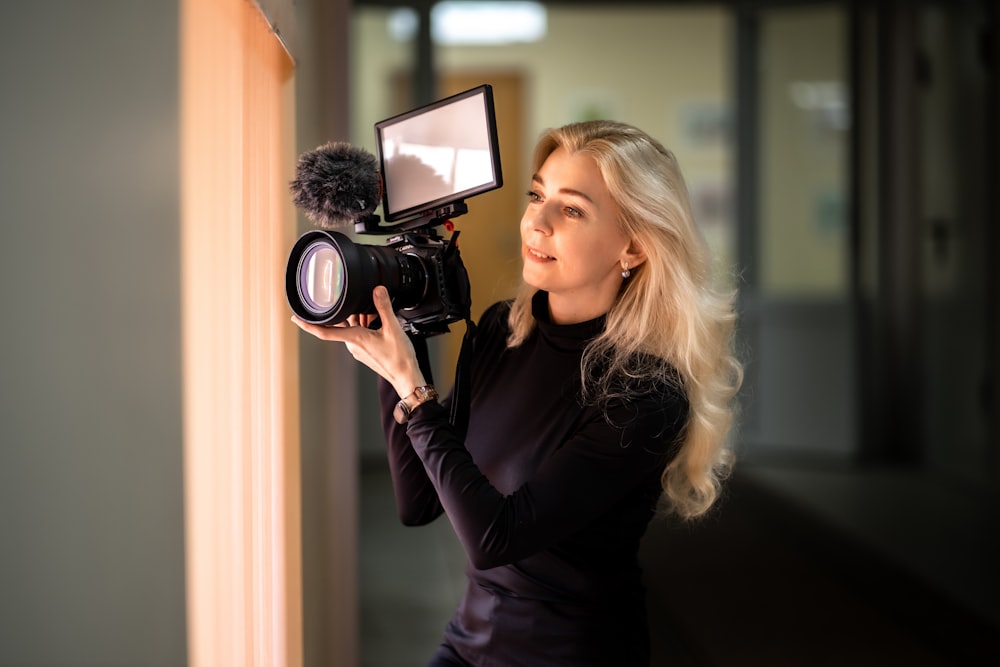 a woman holding a camera up to a mirror