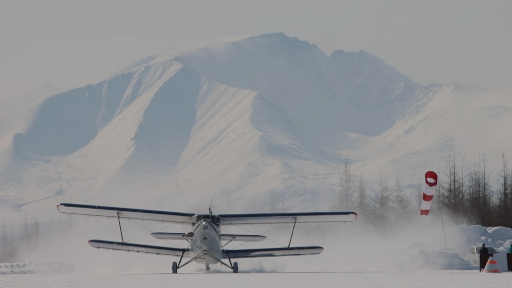 a small plane landing on a snowy runway