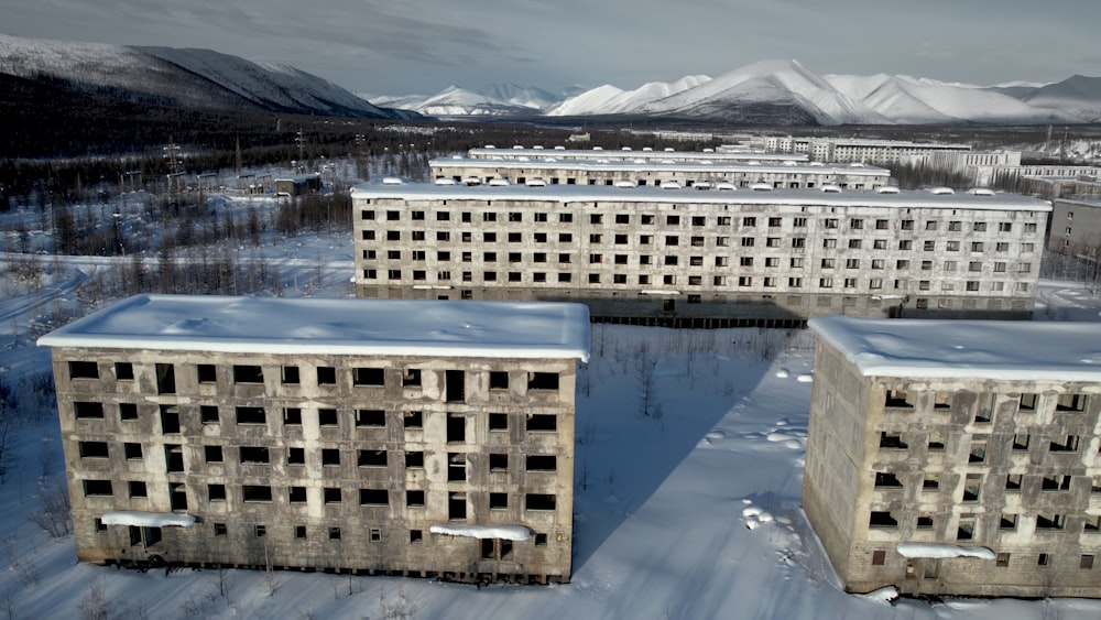 a group of buildings in the middle of a snowy field