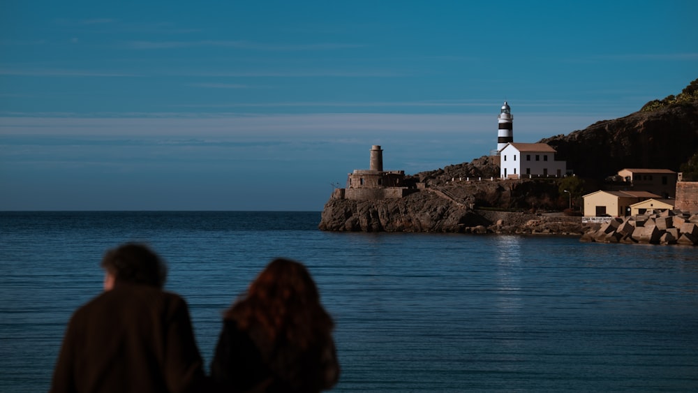 a man and a woman are looking at a lighthouse