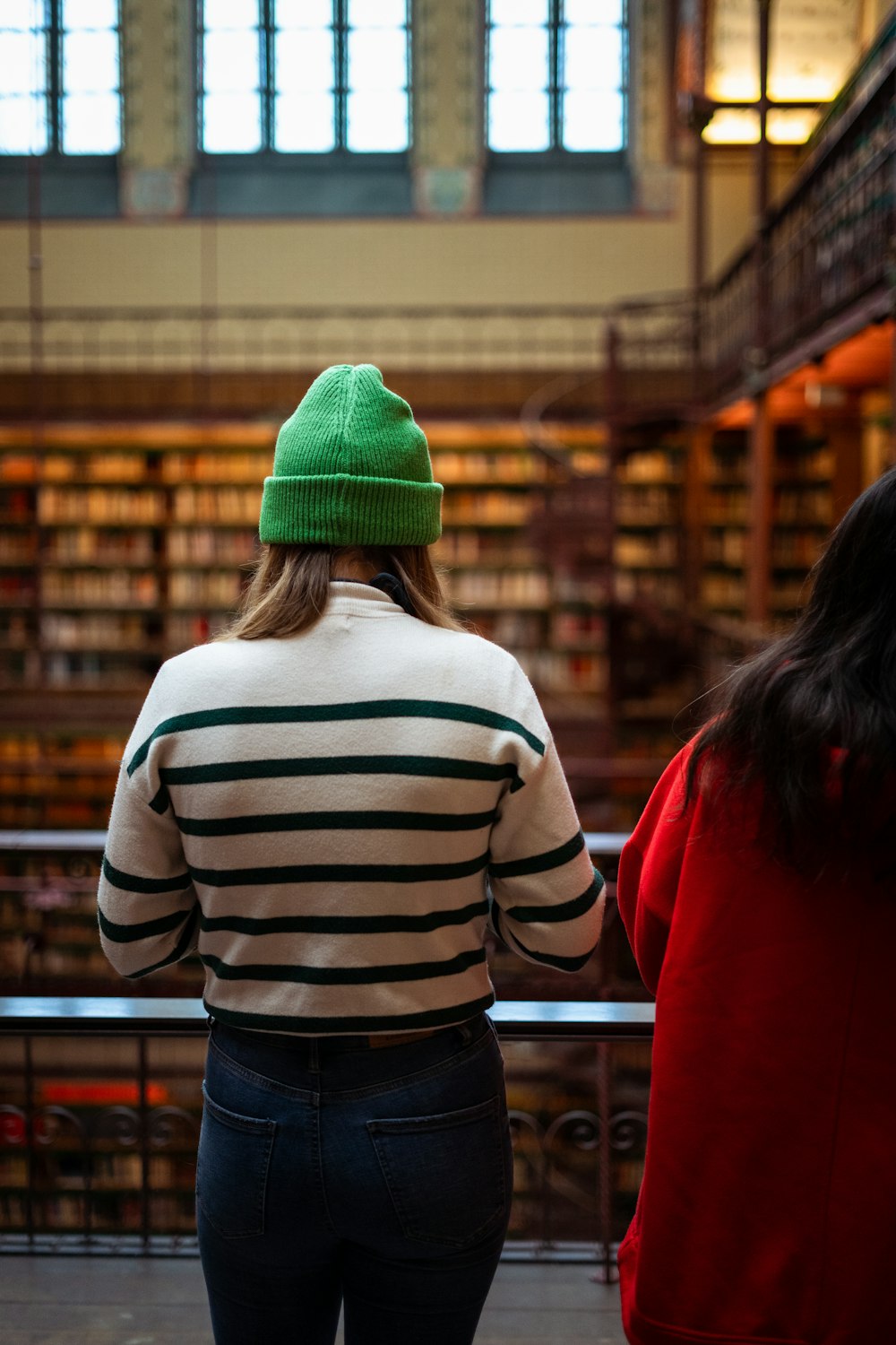 two women standing in a library looking at books