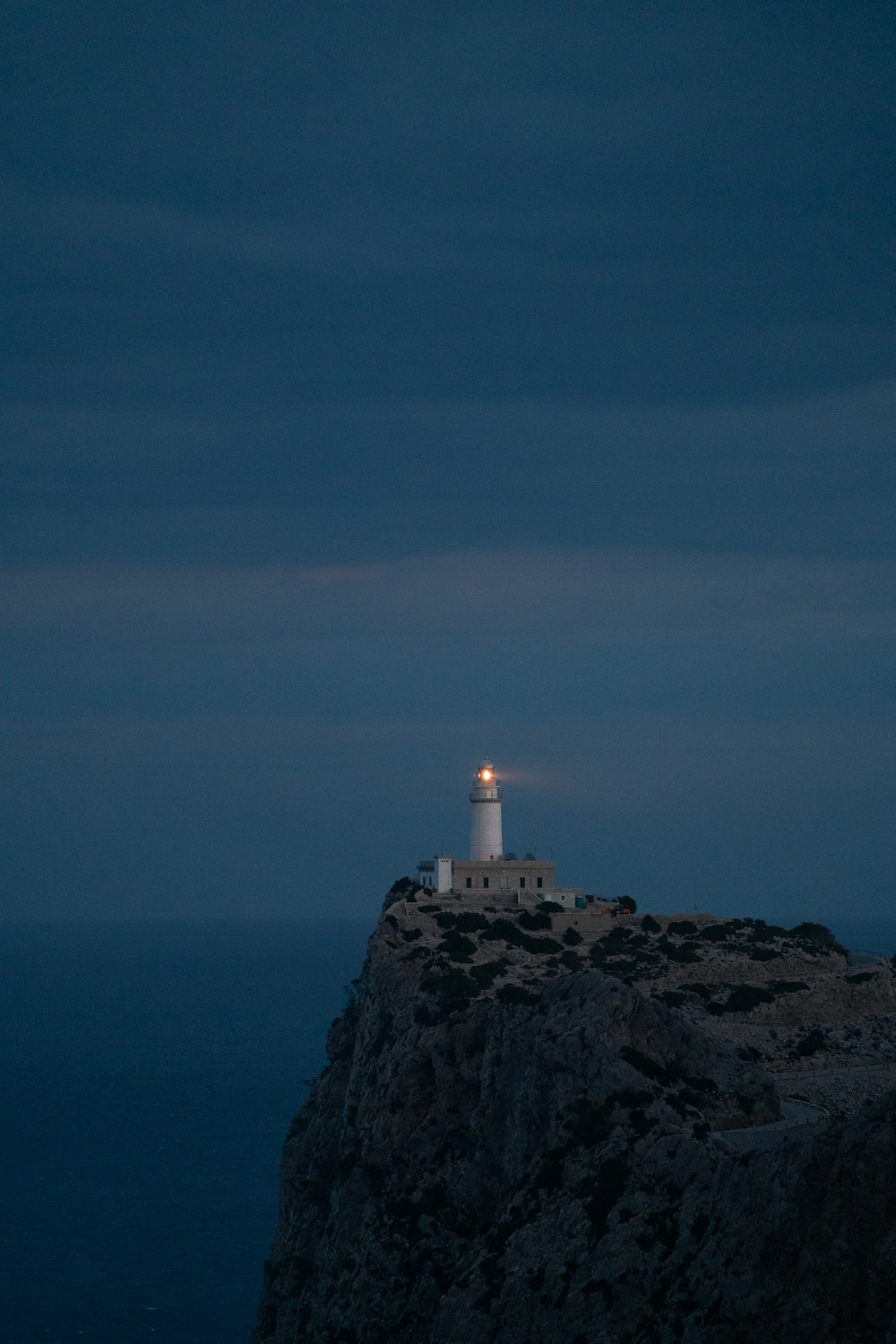 a lighthouse on top of a cliff at night