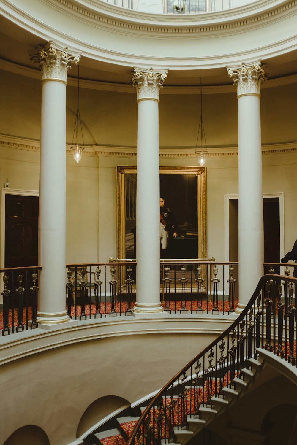 a man standing on a balcony next to a spiral staircase