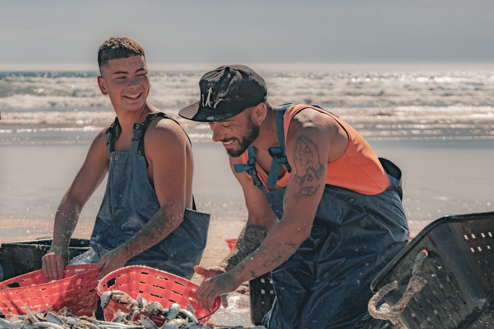 Un couple d’hommes debout l’un à côté de l’autre sur une plage