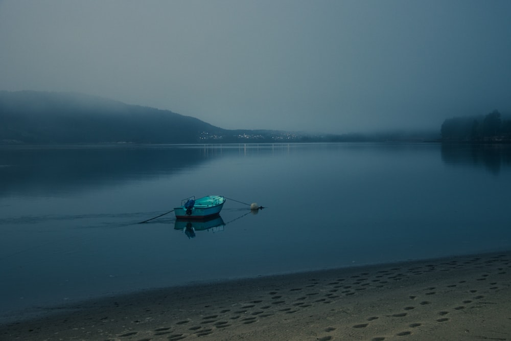 a boat is sitting on the shore of a lake