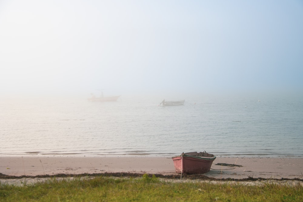 a boat sitting on the beach in the fog