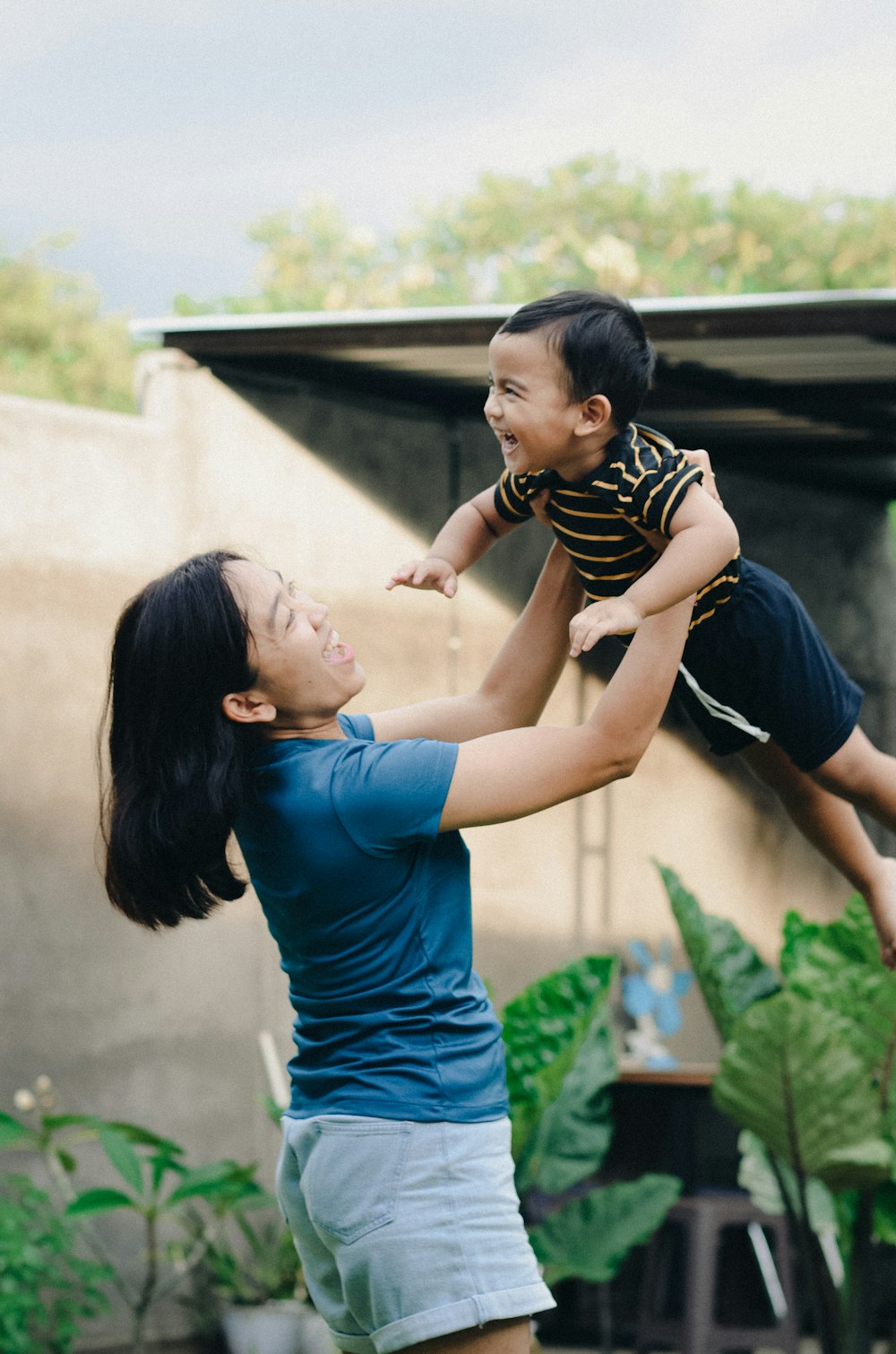 a woman holding a child up in the air