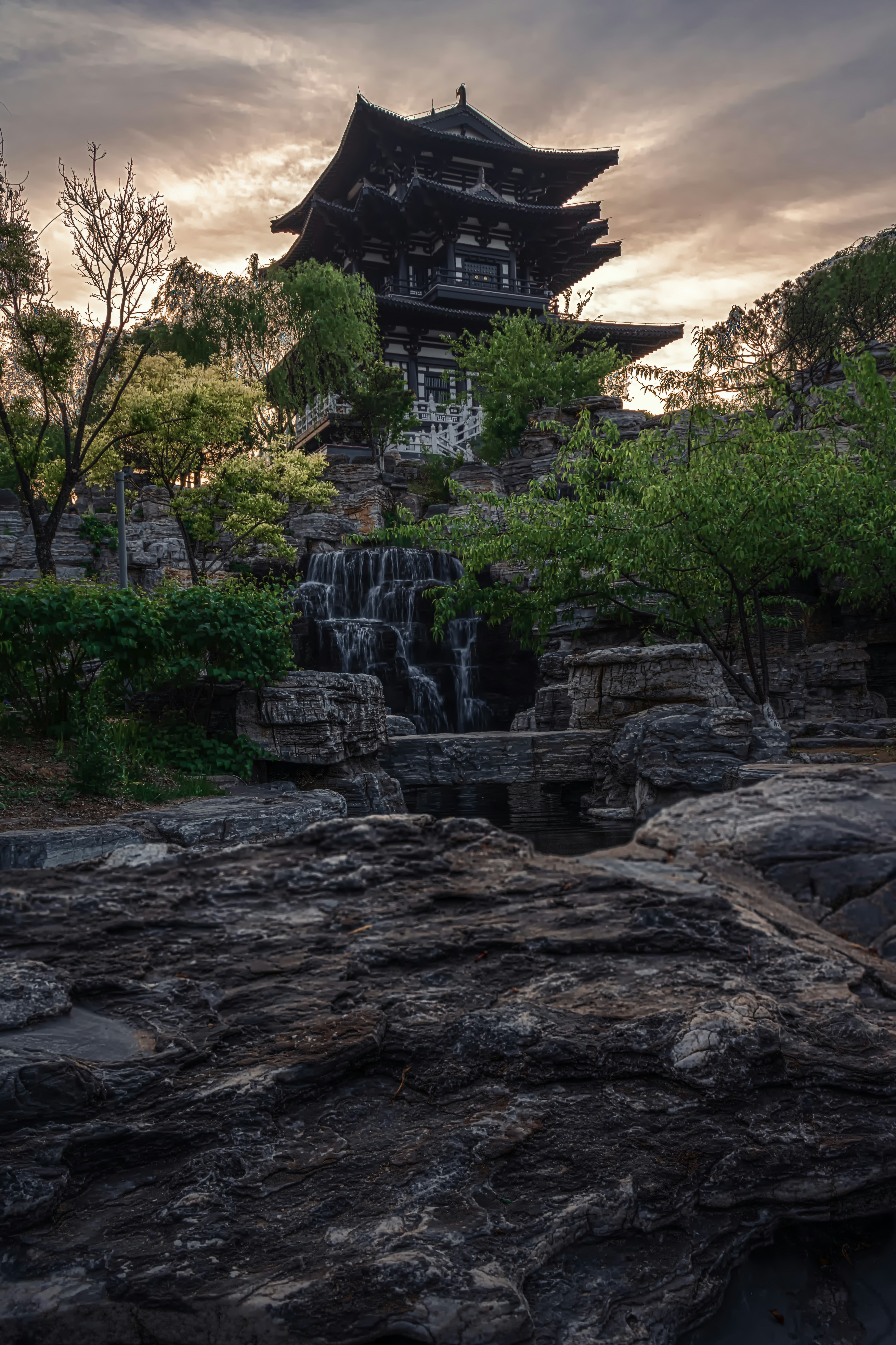 A building with a waterfall in front of it photo – Free Outdoors Image ...