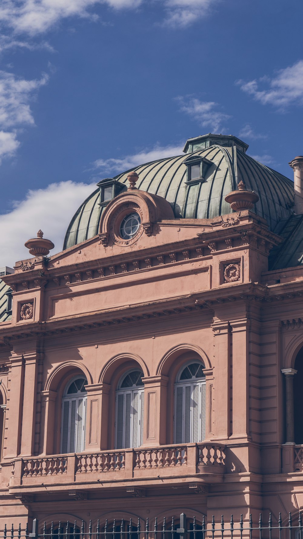 a pink building with a green dome on top