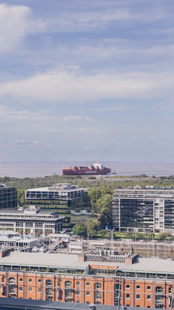 A candid photo of the diverse Hafenverve team standing confidently in front of the bustling Hamburg port.