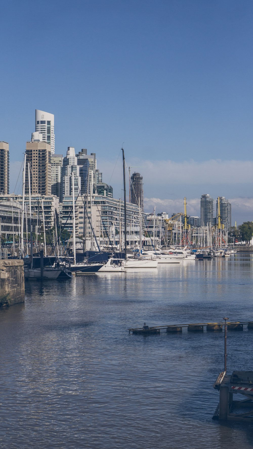 a harbor filled with lots of boats next to tall buildings