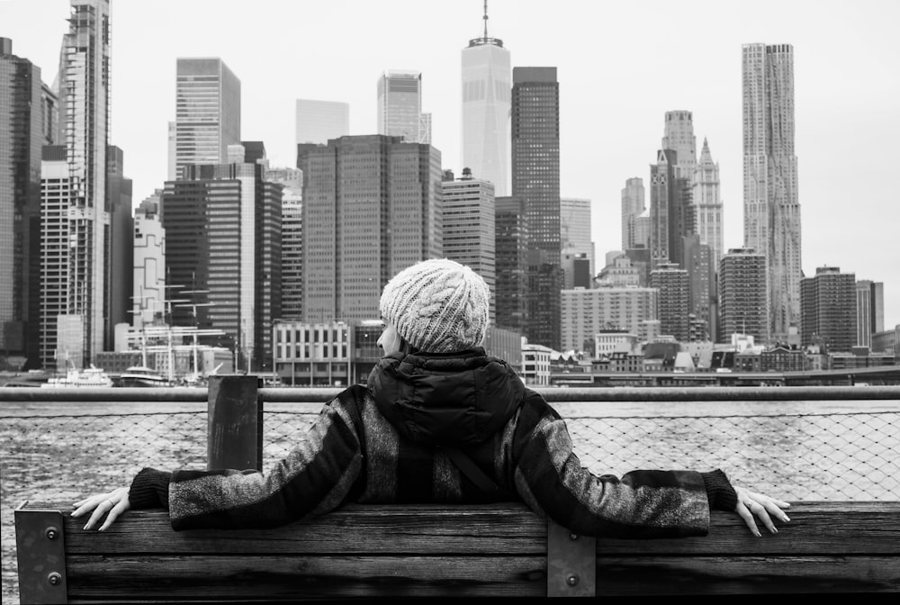 a person sitting on a bench looking at the city