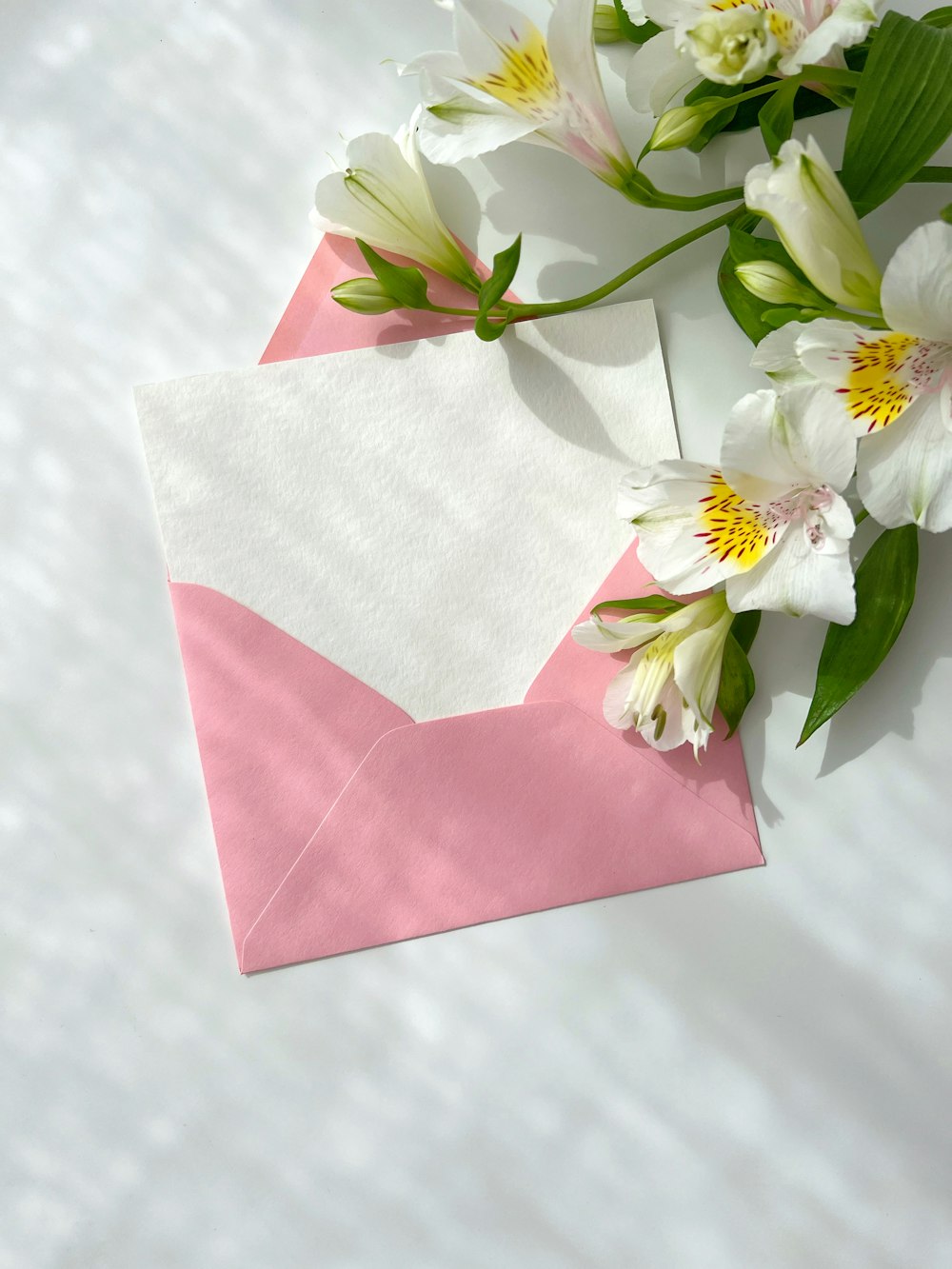a pink envelope with white flowers on it