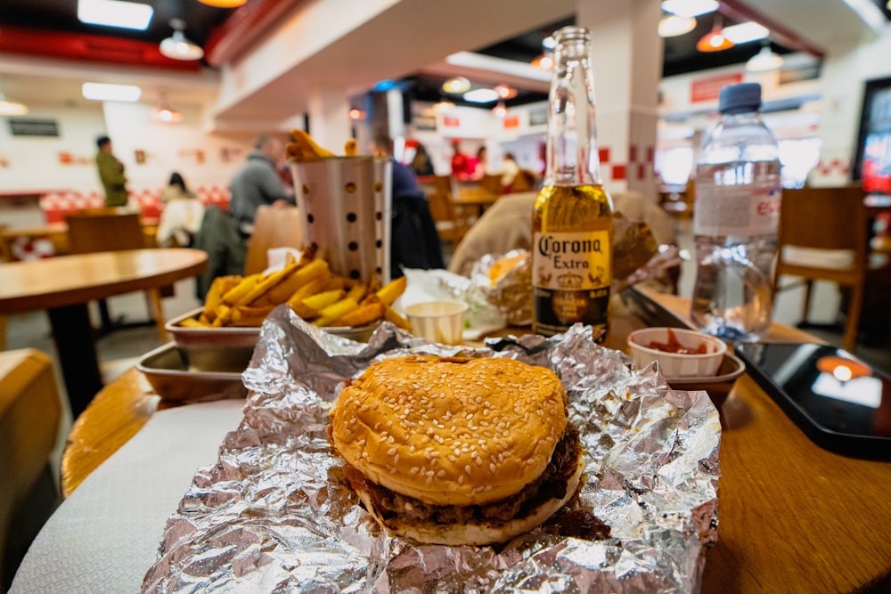 a hamburger sitting on top of a table covered in tin foil