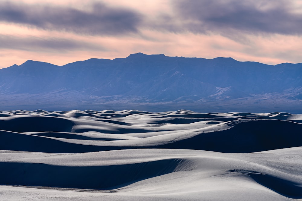 a view of a desert with mountains in the background