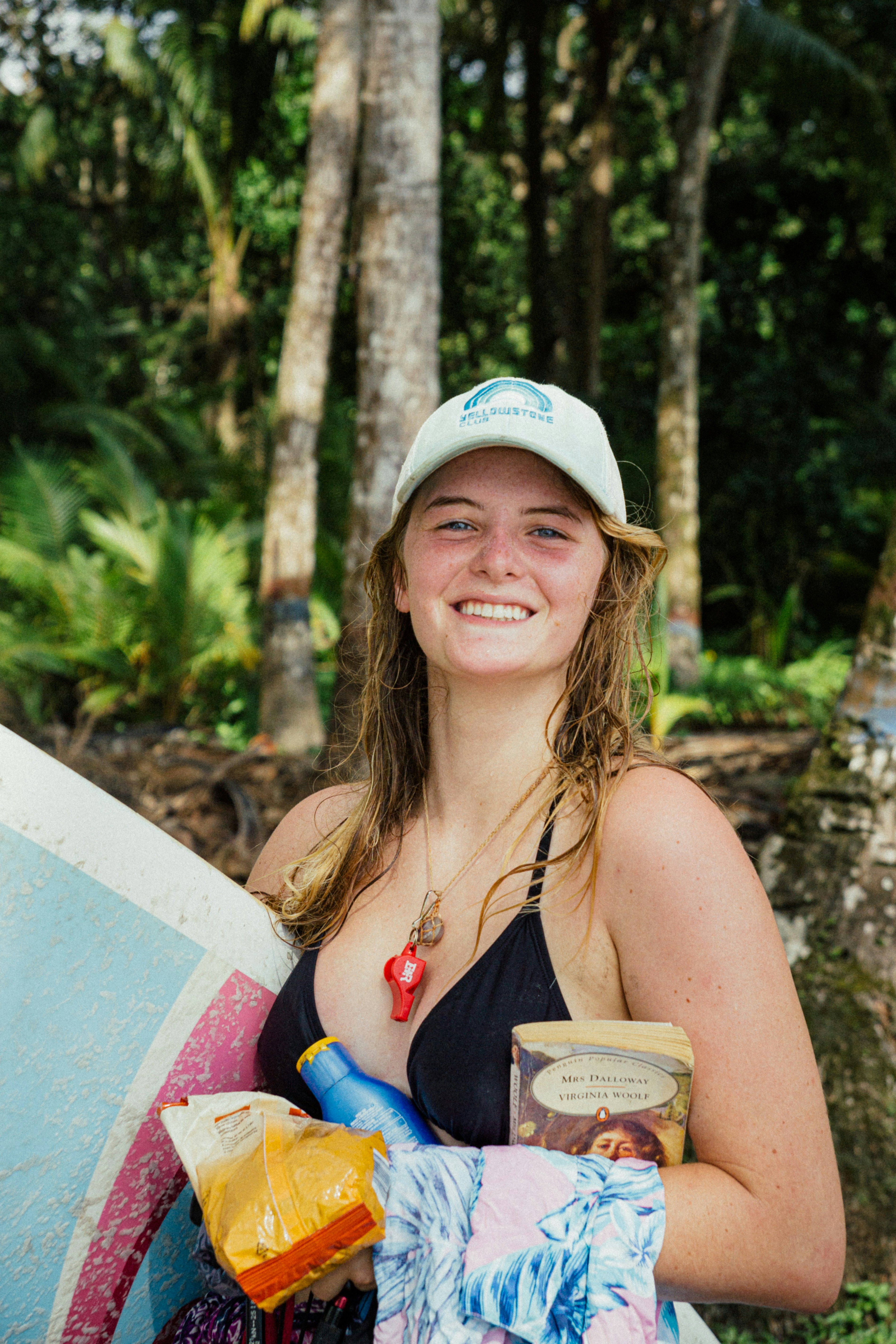 a woman holding a surfboard and a cup of coffee