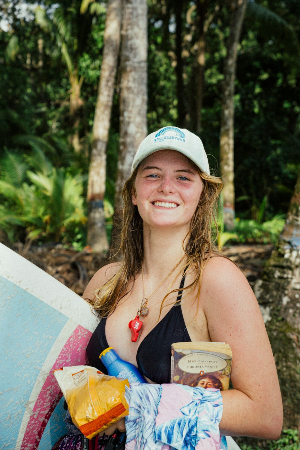a woman holding a surfboard and a cup of coffee