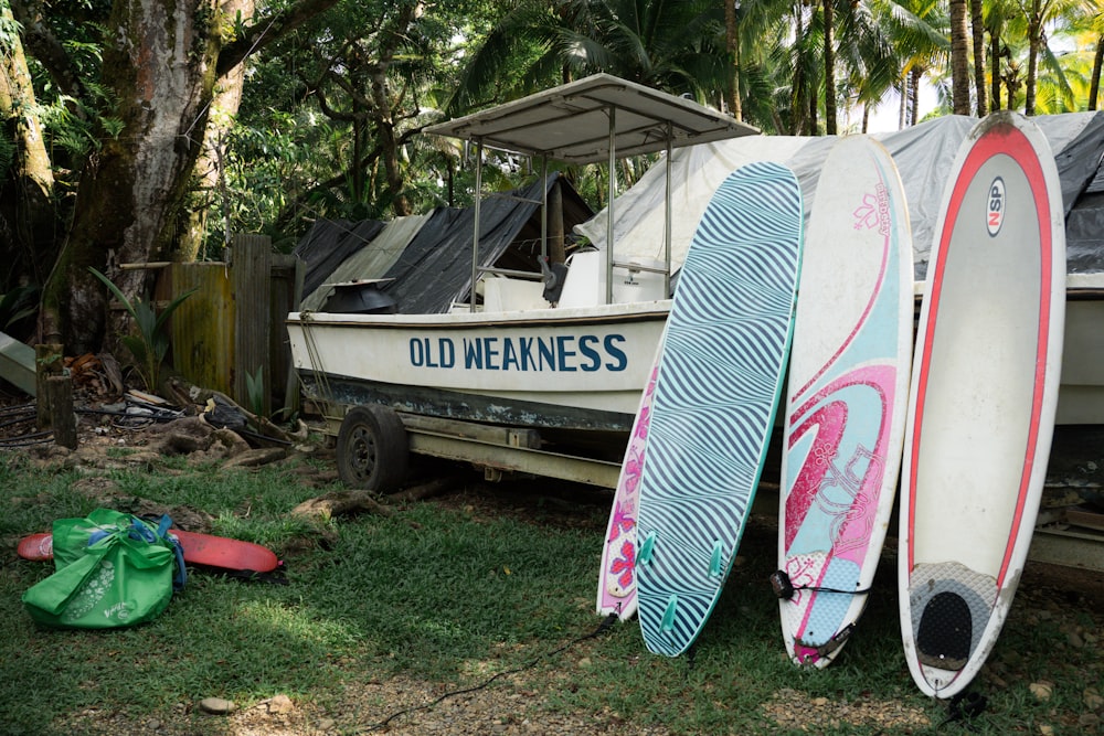 a row of surfboards sitting next to a boat