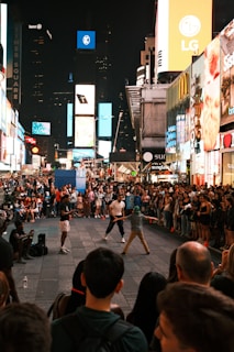 Crowd gathered in Times Square, captivated by the live fashion spectacle under towering digital billboards.