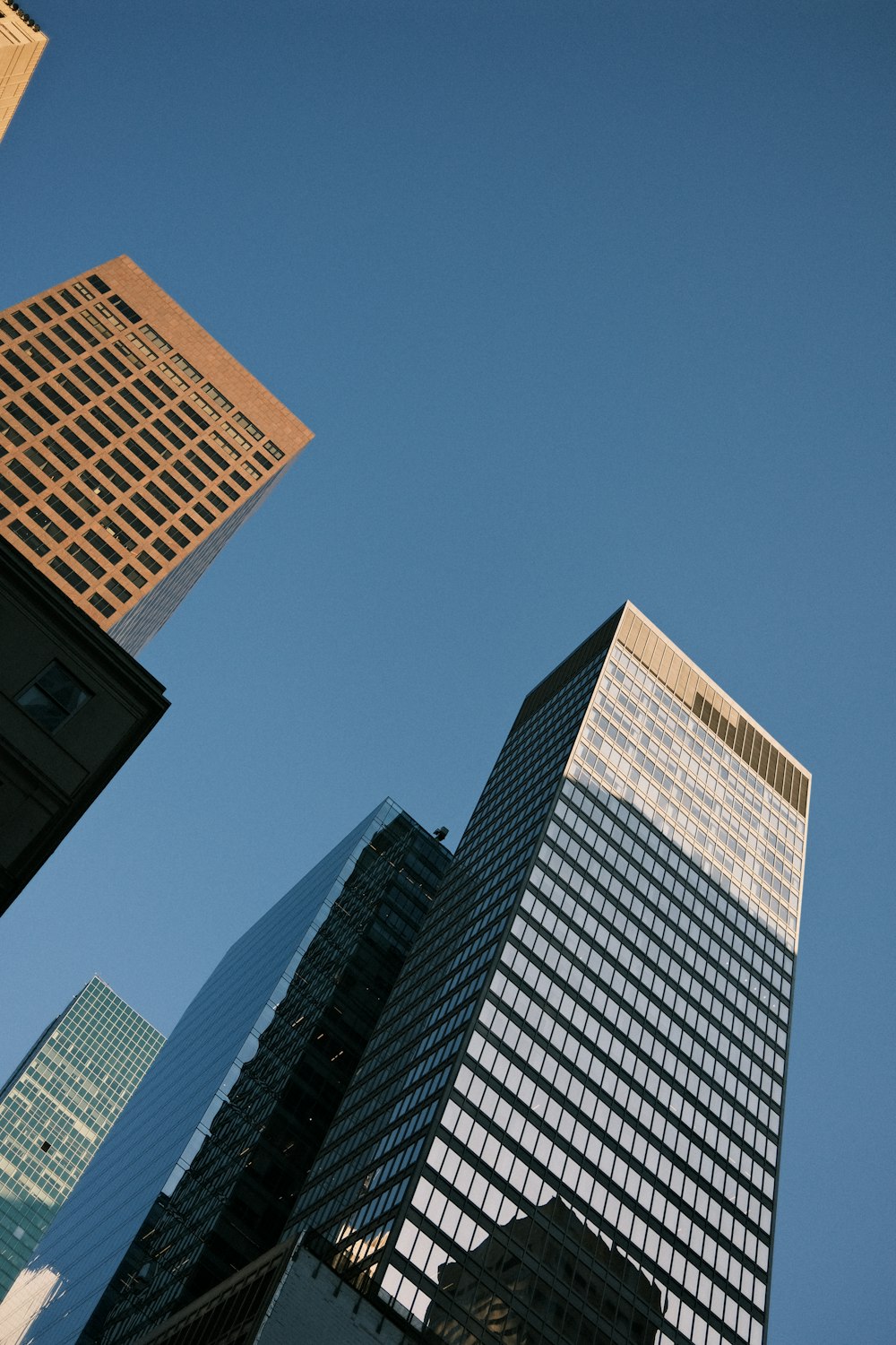 a group of tall buildings with a blue sky in the background