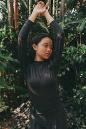 a woman standing in front of a bamboo tree