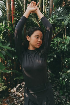 a woman standing in front of a bamboo tree