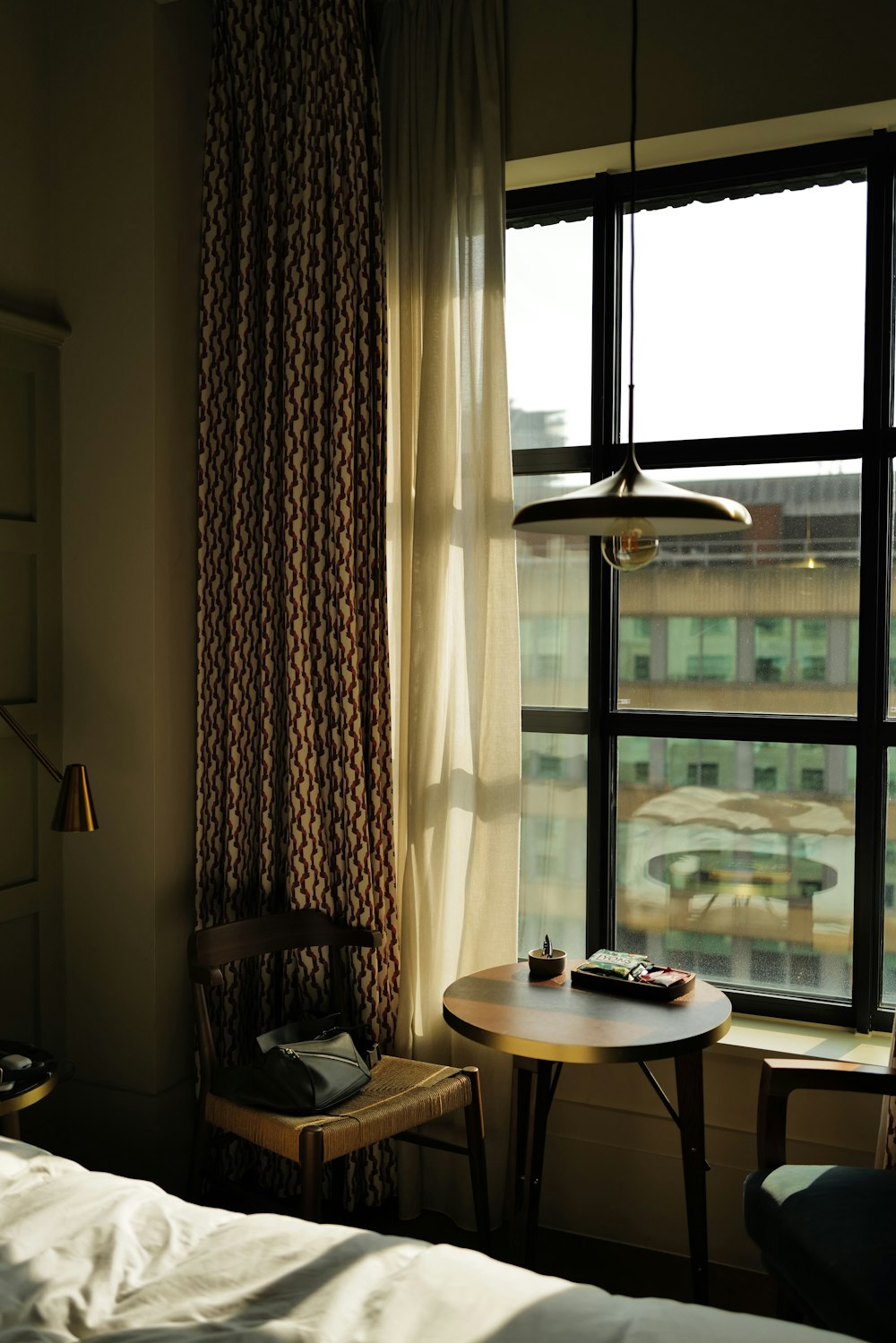 a bedroom with a table, chair, and window