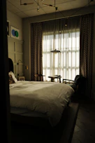 A sunlit bedroom featuring a king-size bed with plush linens and a cozy reading nook by the window.