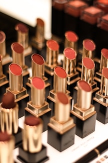 Brightly lit display of colorful makeup palettes and lipsticks on modern shelves.