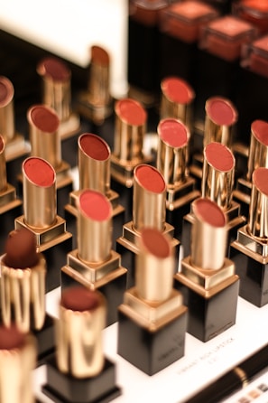 An elegant display of lipsticks in various shades lined up on a marble countertop.