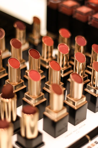Close-up of vibrant lipsticks in various shades arranged artistically on a soft fabric background.