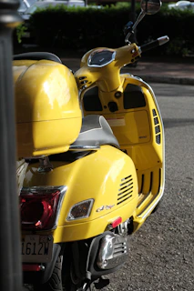A sleek, shiny scooter parked on a sunny city street, ready for rent.