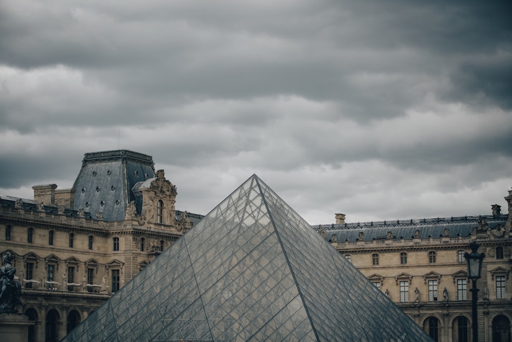 a large building with a very tall pyramid in front of it