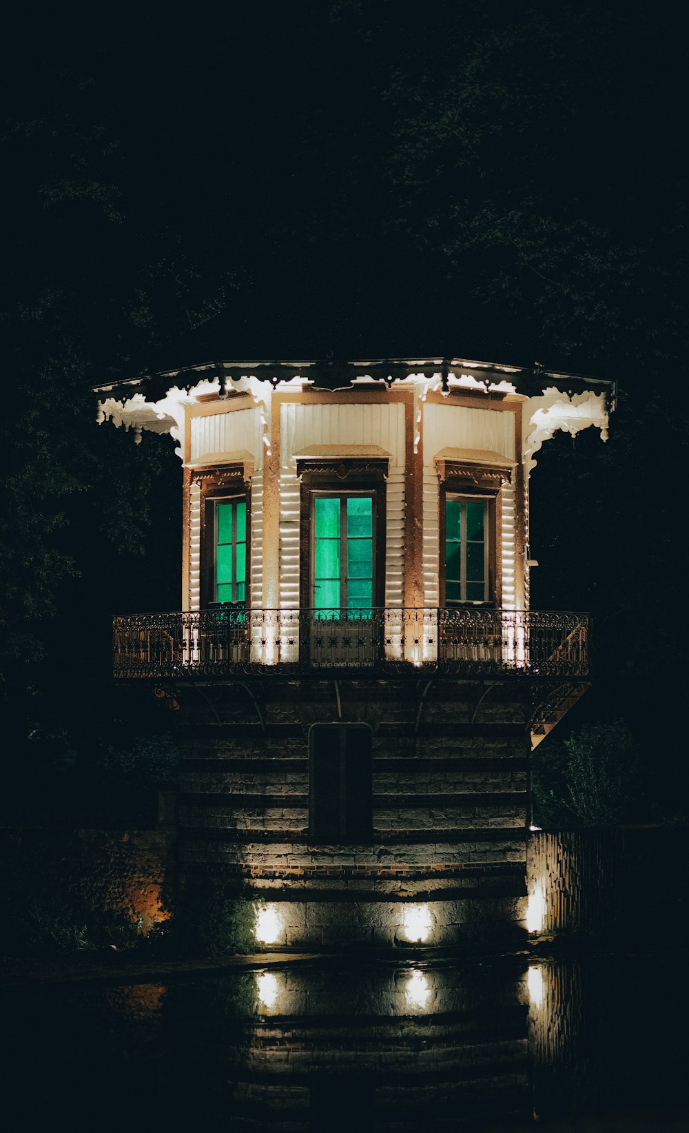 a lit up gazebo sitting in the middle of a forest