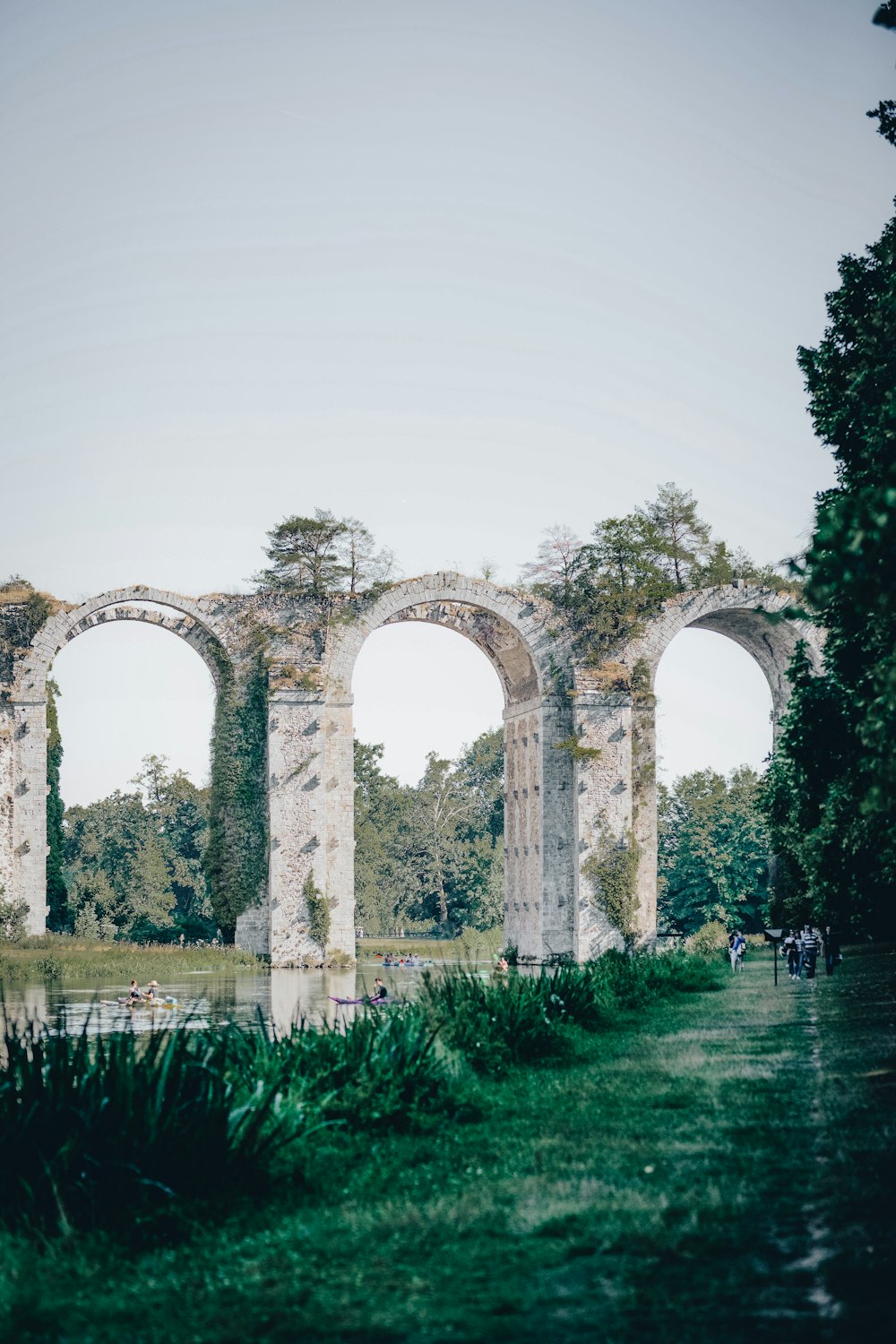 a stone arch in the middle of a field