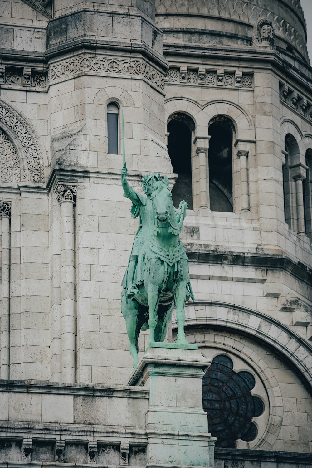 a statue of a man on a horse in front of a building