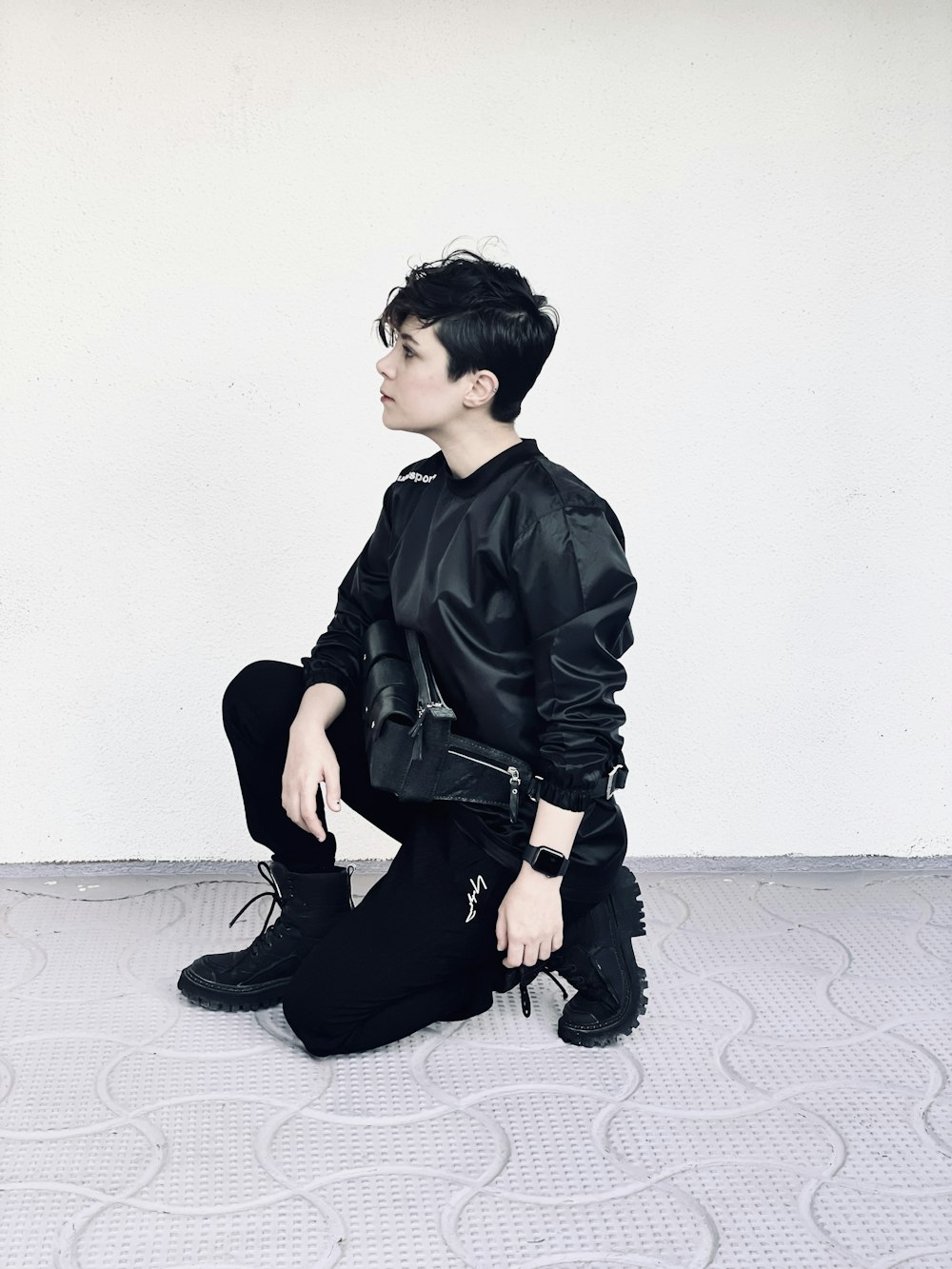 a person sitting on a floor with a black jacket on