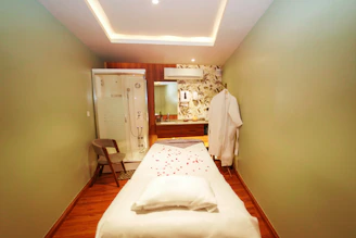 A serene treatment room with soft linens and warm lighting.