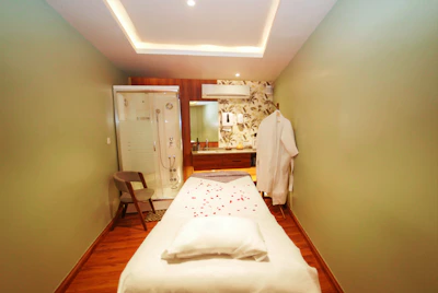 Peaceful hotel room setting with a therapist preparing massage oils.