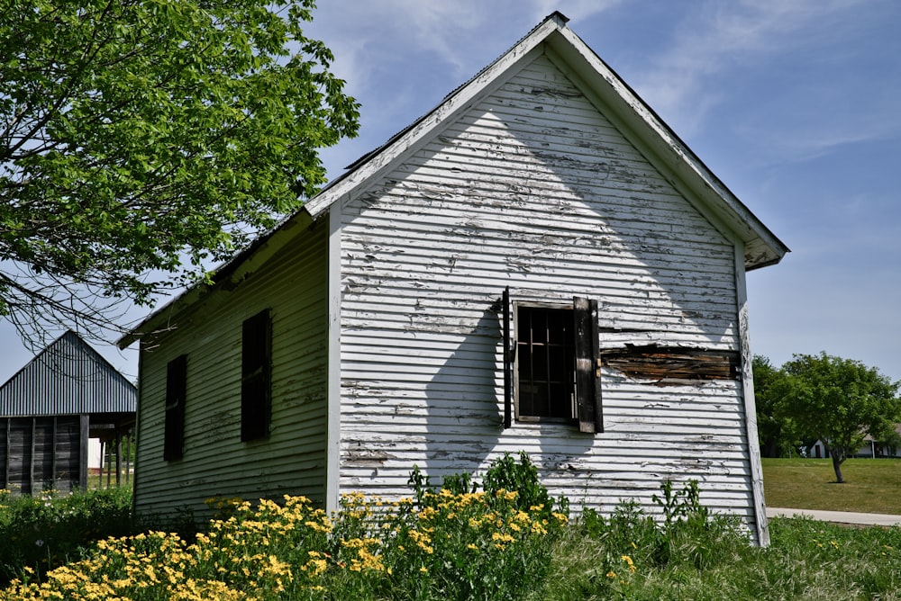 an old white house with a broken window